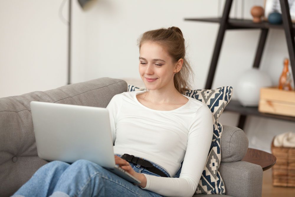 Financial Advice Contact - happy young lady using her laptop