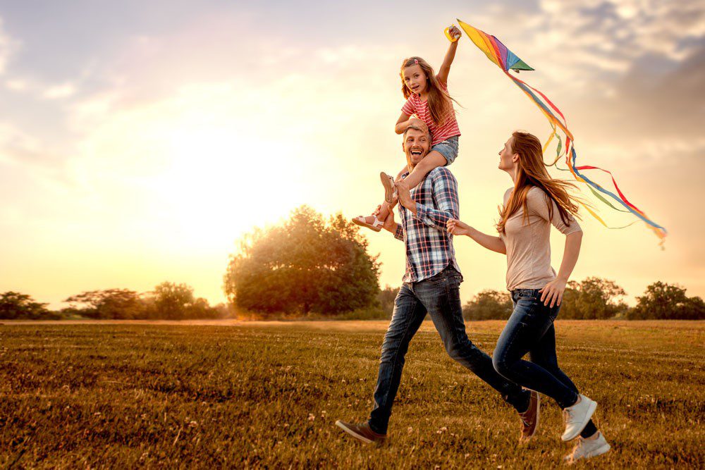 Financial Advice News - happy family playing with flying kite